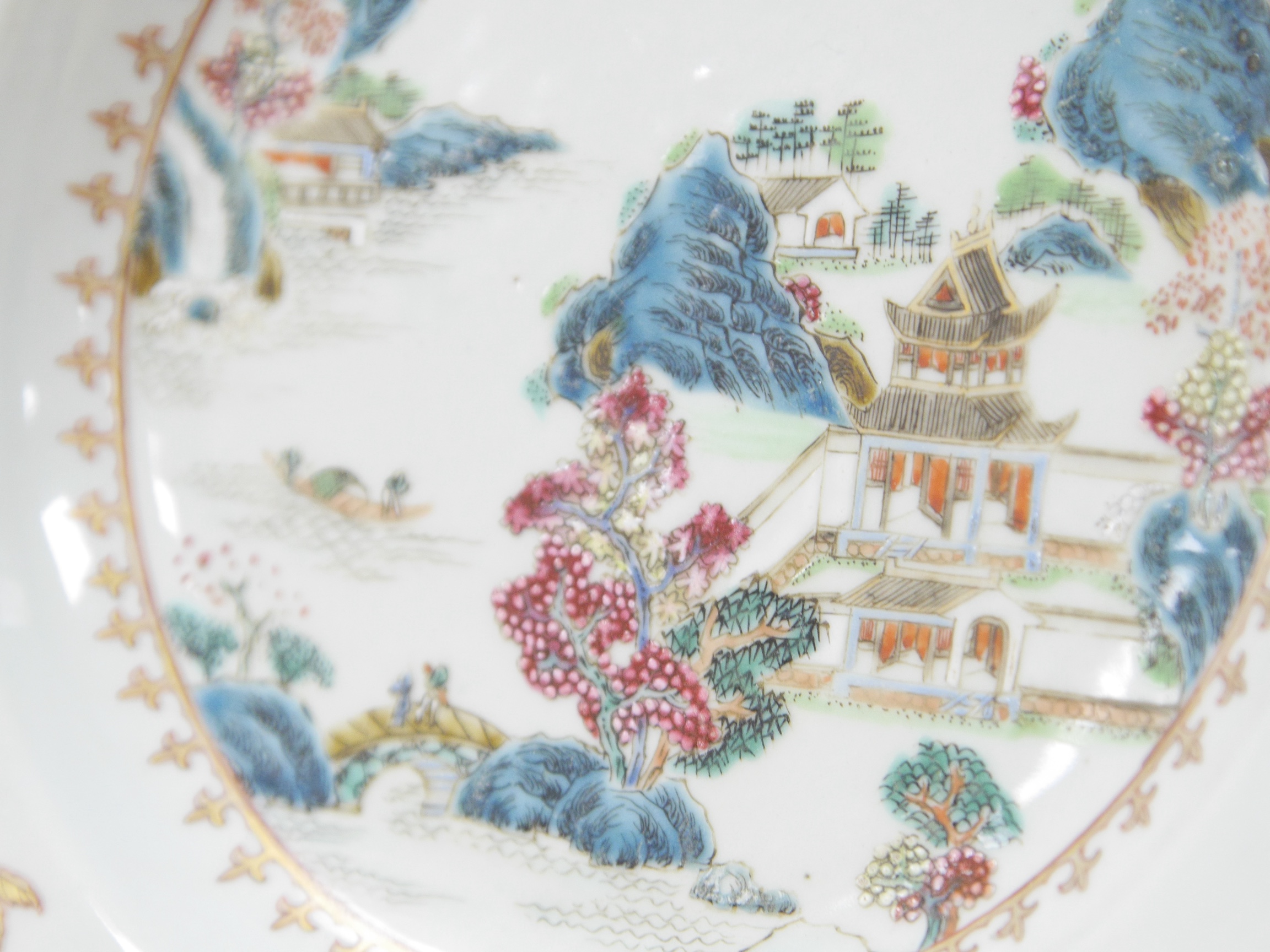 An 18th century Chinese famille rose 'landscape' octagonal plate, 22cm wide. Condition - good, minor chipping